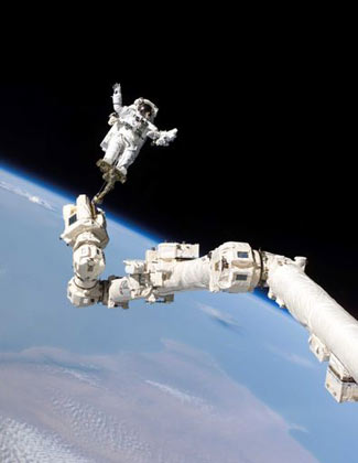 Astronaut Stephen K. Robinson, STS-114 mission specialist, anchored to a foot restraint on the International Space Station’s Canadarm2