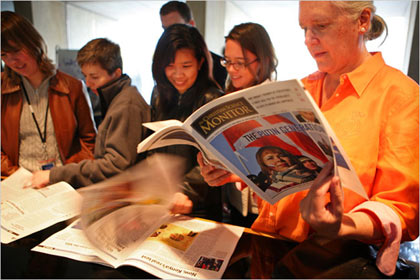 employees of The Monitor looking through a prototype of a weekly newsmagazine that will supplement the Web site