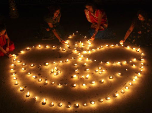 women light lamps in Ahmedabad, Western India, on the eve of Diwali, the Hindu festival of lights