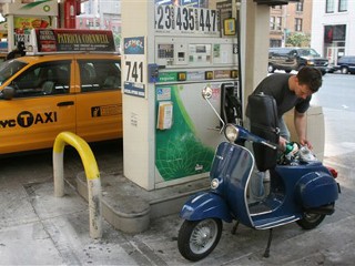 New York resident Austin Rommett fills his scooter with fuel at a gas station in New York