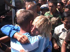 Kathleen Mitchinson embraces husband Ernest Lewandowsky as she and other divers arrive on Flores island in Indonesia