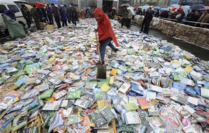 local official shovels pirated DVDs before destroying them during a campaign in Taiyuan, Shanxi province, April 20, 2008 local official shovels pirated DVDs before destroying them during a campaign in Taiyuan, Shanxi province, April 20, 2008