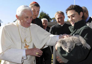 the Pope, accompanied by Cardinal Pell, pats a koala named Darwin at the Kenthurst Study Center
