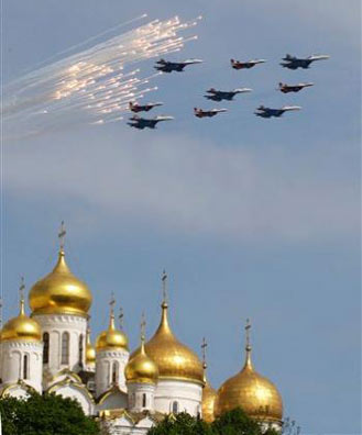 Russian fighter jets launch flares as they fly above the Moscow Kremlin cathedrals' gold-plated domes