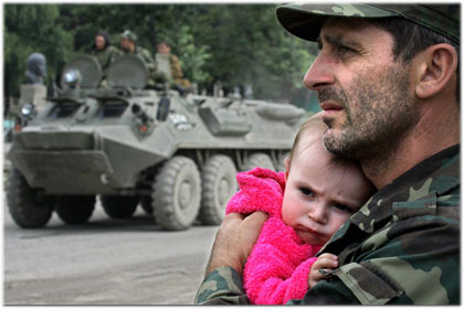 A South Ossetian soldier holds a child as he watches an armored vehicle roll through the village of Dzhava, Georgia A South Ossetian soldier holds a child as he watches an armored vehicle roll through the village of Dzhava, Georgia