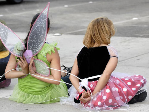 Cinderella, Snow White, Tinkerbell and other fictional fixtures of modern-day childhood arrested outside Disneyland