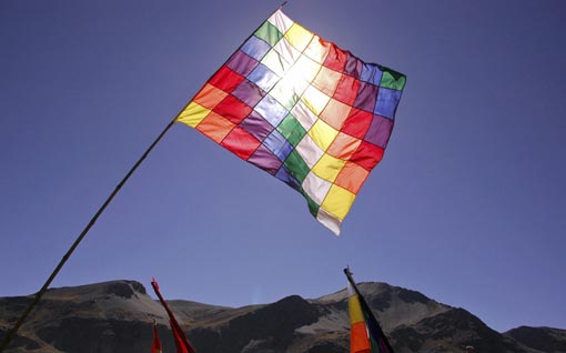 a Bolivian Wiphala indigenous flag (this one representing the Qulla Suyu region of the Inca Empire) is held high during a protest march towards La Paz, Bolivia on October 20, 2008