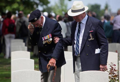 Normandy Veteran Fredrick William Norris, who was awarded the Military Medal, passes the graves of friends from his regiment, the 5th Assualt Regiment of the Armoured Engineers