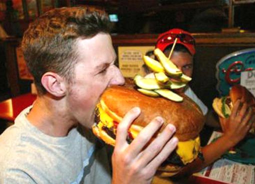 fat person eating burger. stupid move: Eating junk food