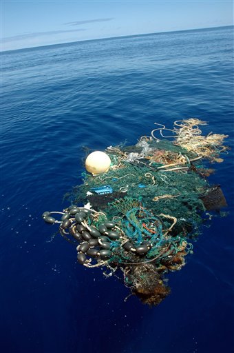 Matt Durham, center, pulling in a large patch of sea garbage with the help of Miriam Goldstein, right, Aug. 11, 2009 in the Pacific Ocean. Scientists at Scripps Institution of Oceanography on Thursday Aug. 27, 2009 announced findings from an August expedition to the Great Pacific Garbage Patch, about 1,000 miles west of California. The patch is a vortex formed by ocean currents and collects human-produced trash.