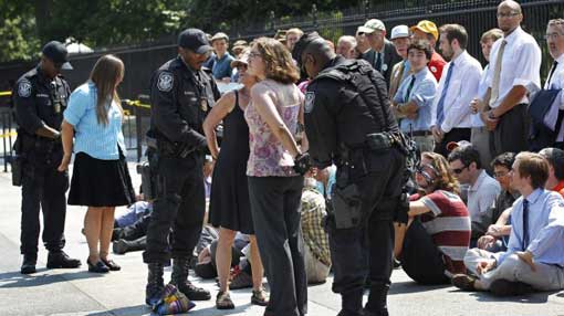 US Park Police officers handcuff and arrest protestors over a proposed pipeline to bring tar sands oil from Canada, in front of the White House in Washington, Saturday, Aug. 20, 2011