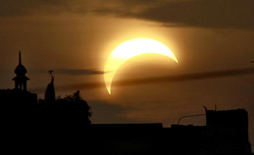 a partial solar eclipse behind a mosque in Hyderabad, Pakistan, Wednesday
